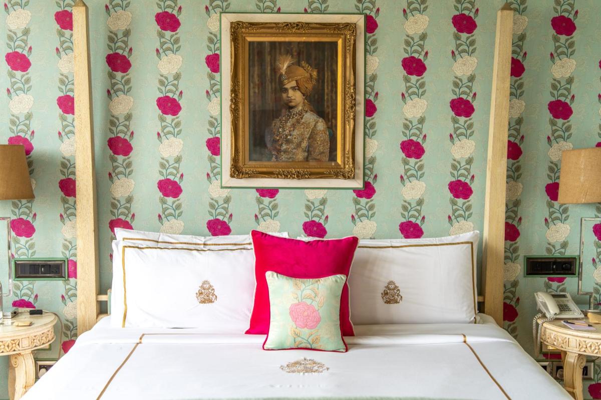a bedroom with a bed with a painting on the wall at Rajmahal Palace RAAS in Jaipur