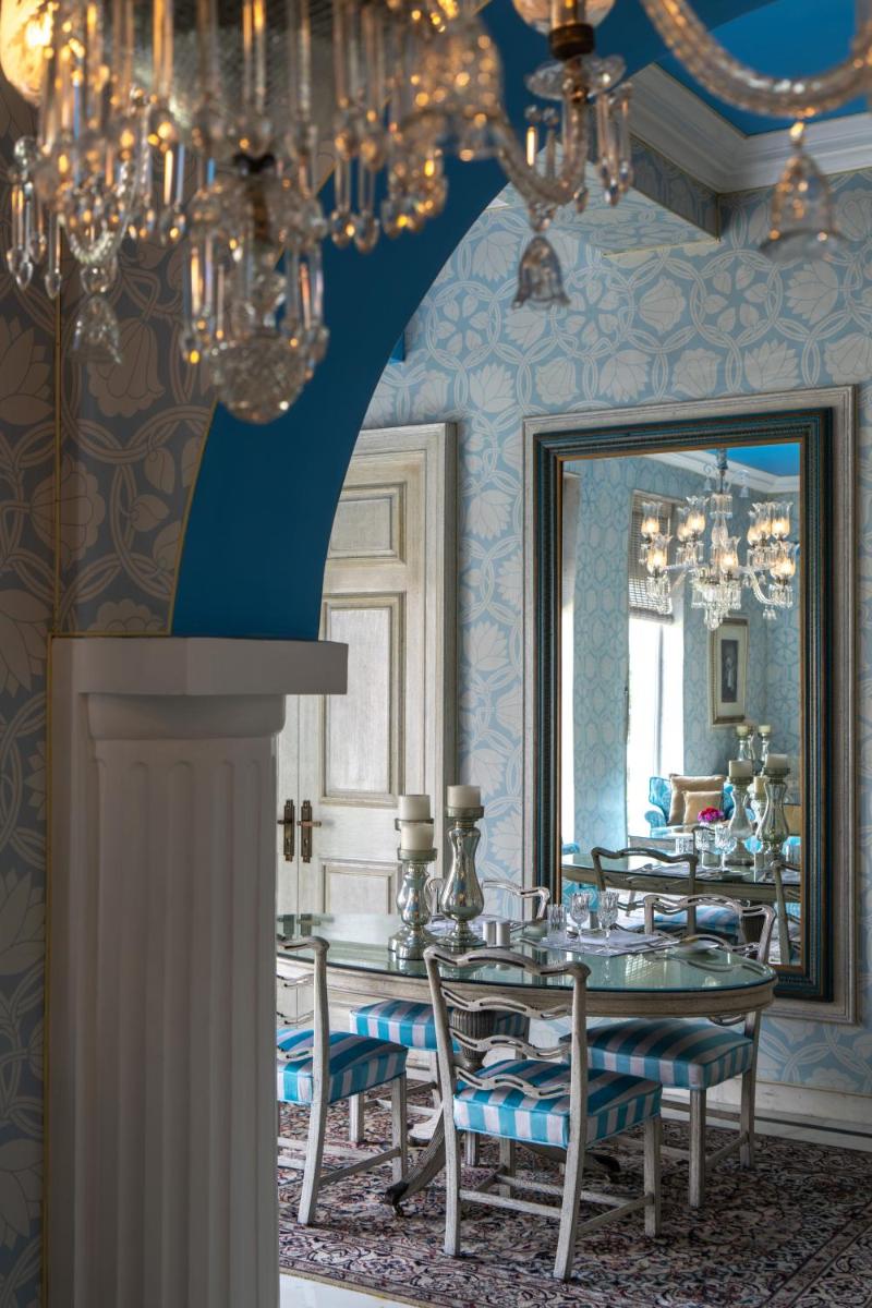 a dining room with a table and a mirror at Rajmahal Palace RAAS in Jaipur