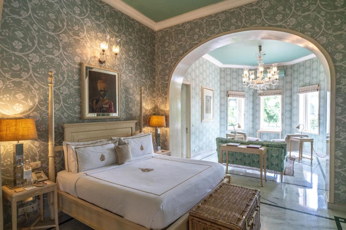 a bedroom with a large bed and a table at Rajmahal Palace RAAS in Jaipur