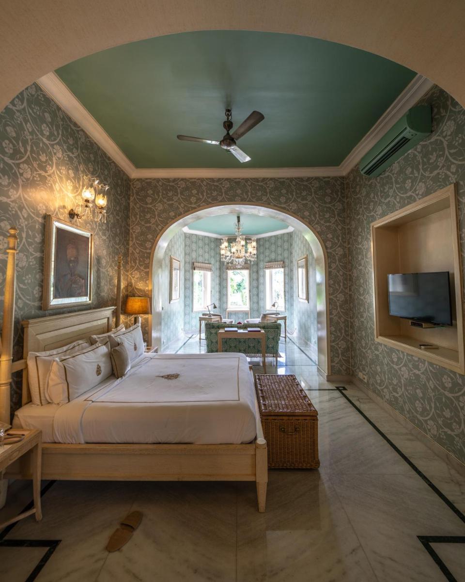 a bedroom with a large bed and a dining room at Rajmahal Palace RAAS in Jaipur