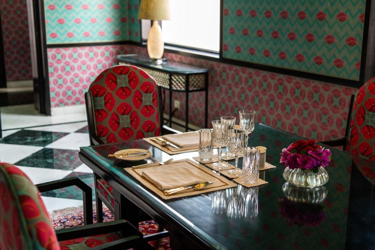 a dining room with a table with plates and glasses at Rajmahal Palace RAAS in Jaipur