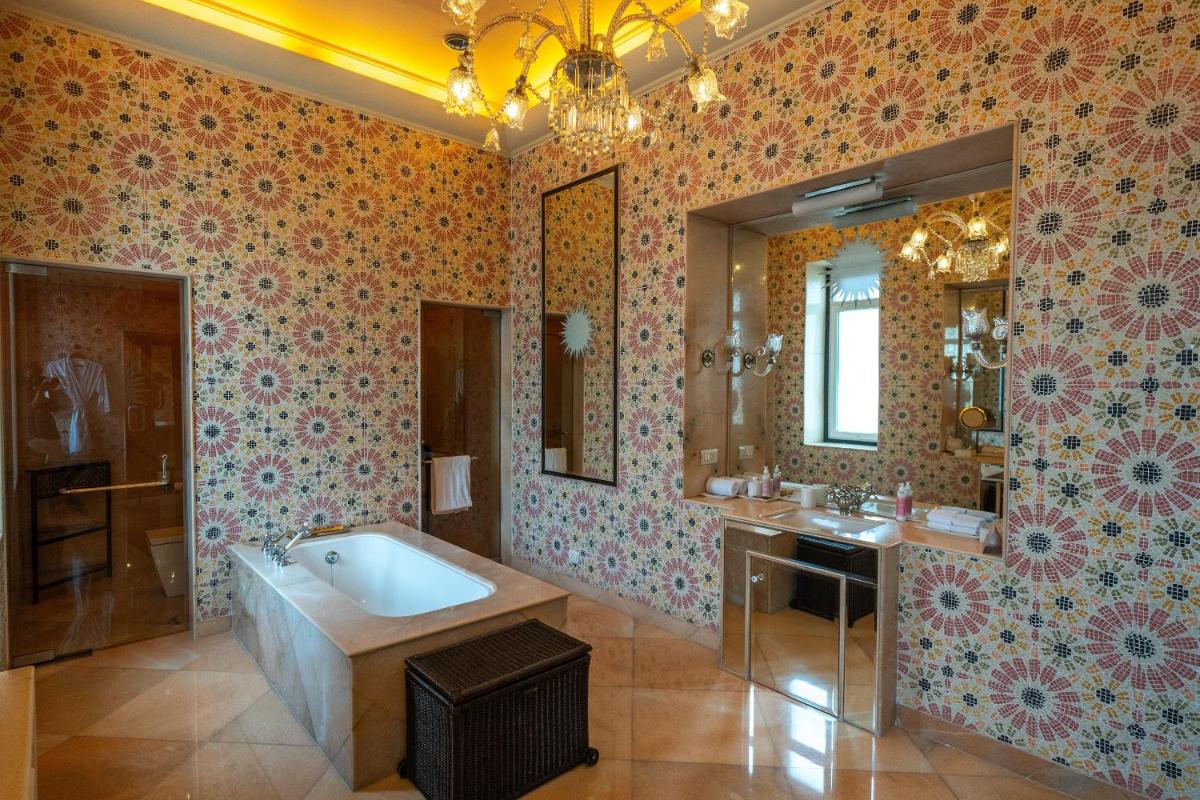 a bathroom with a tub and a sink and a mirror at Rajmahal Palace RAAS in Jaipur
