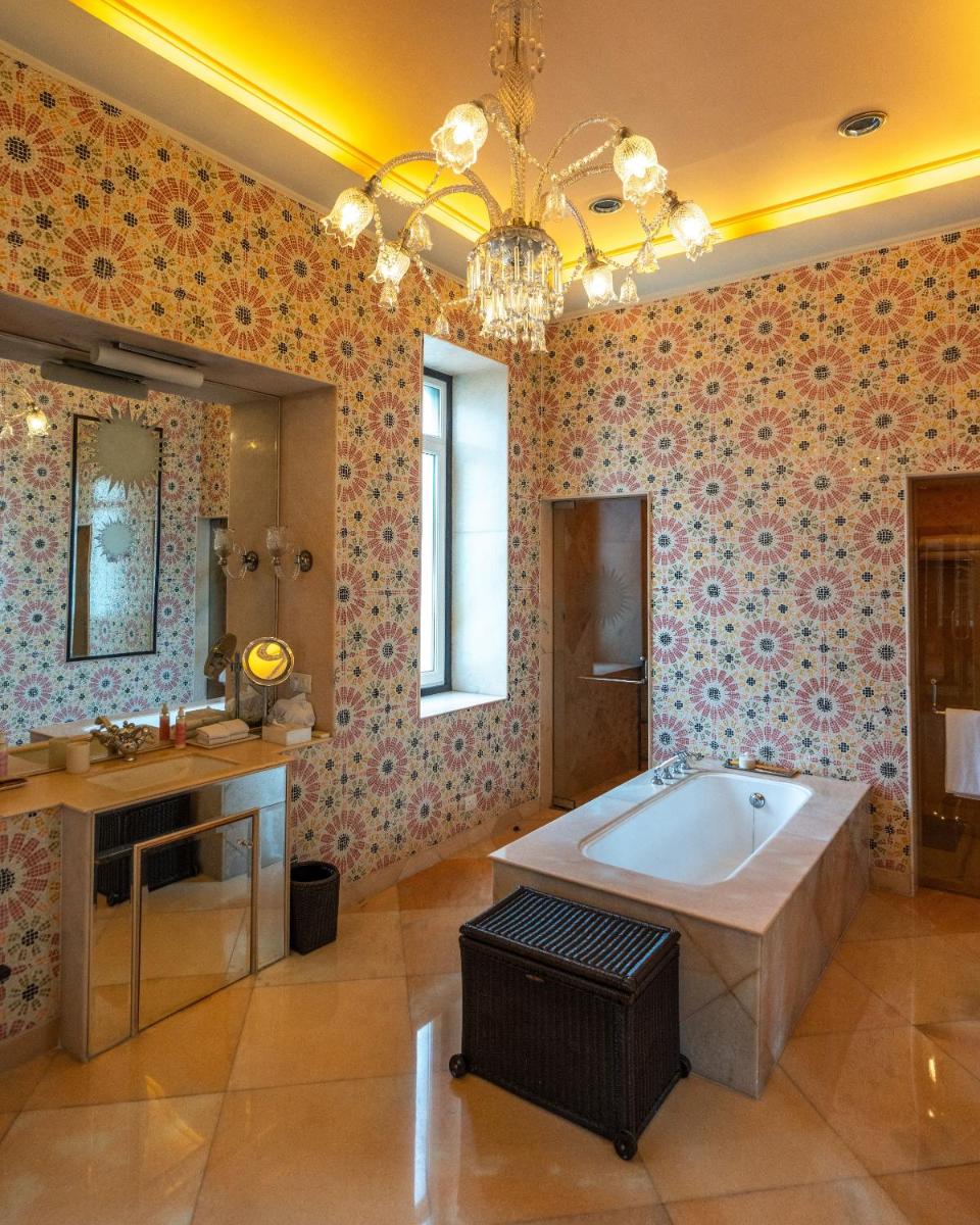 a bathroom with a tub and a sink and a mirror at Rajmahal Palace RAAS in Jaipur