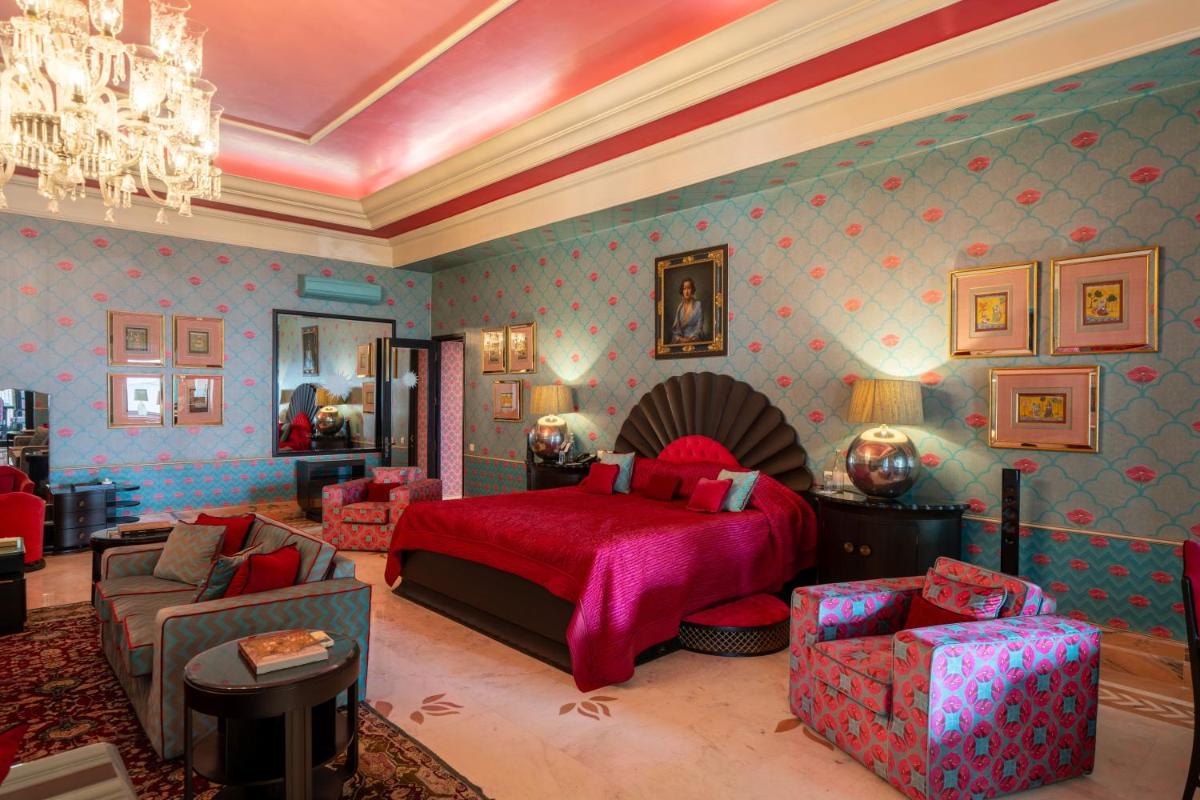 a bedroom with a bed and a couch and chairs at Rajmahal Palace RAAS in Jaipur