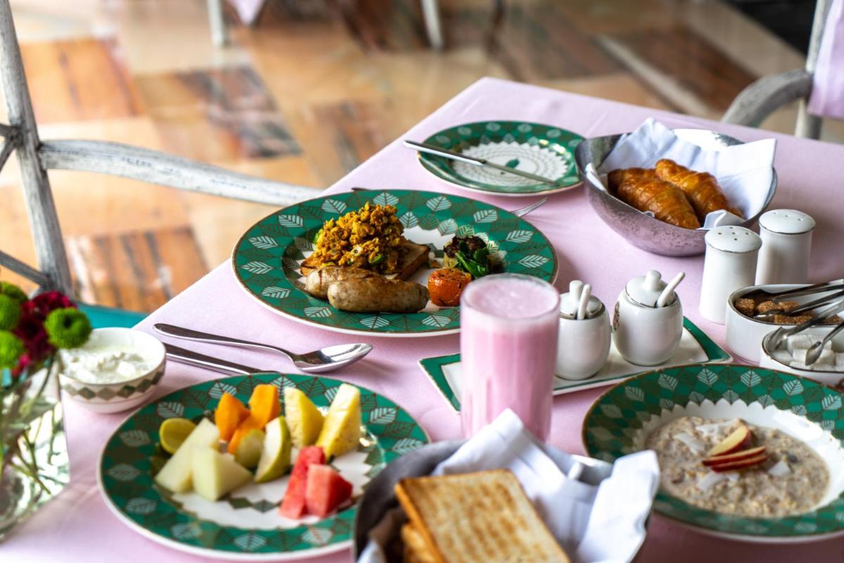 a table with green plates of food on it at Rajmahal Palace RAAS in Jaipur