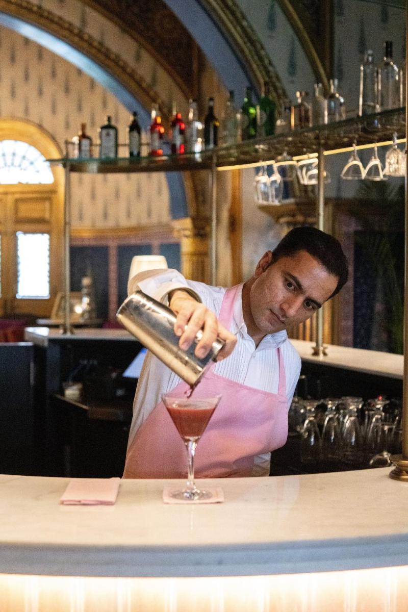 a man is making a drink in a glass at Rajmahal Palace RAAS in Jaipur