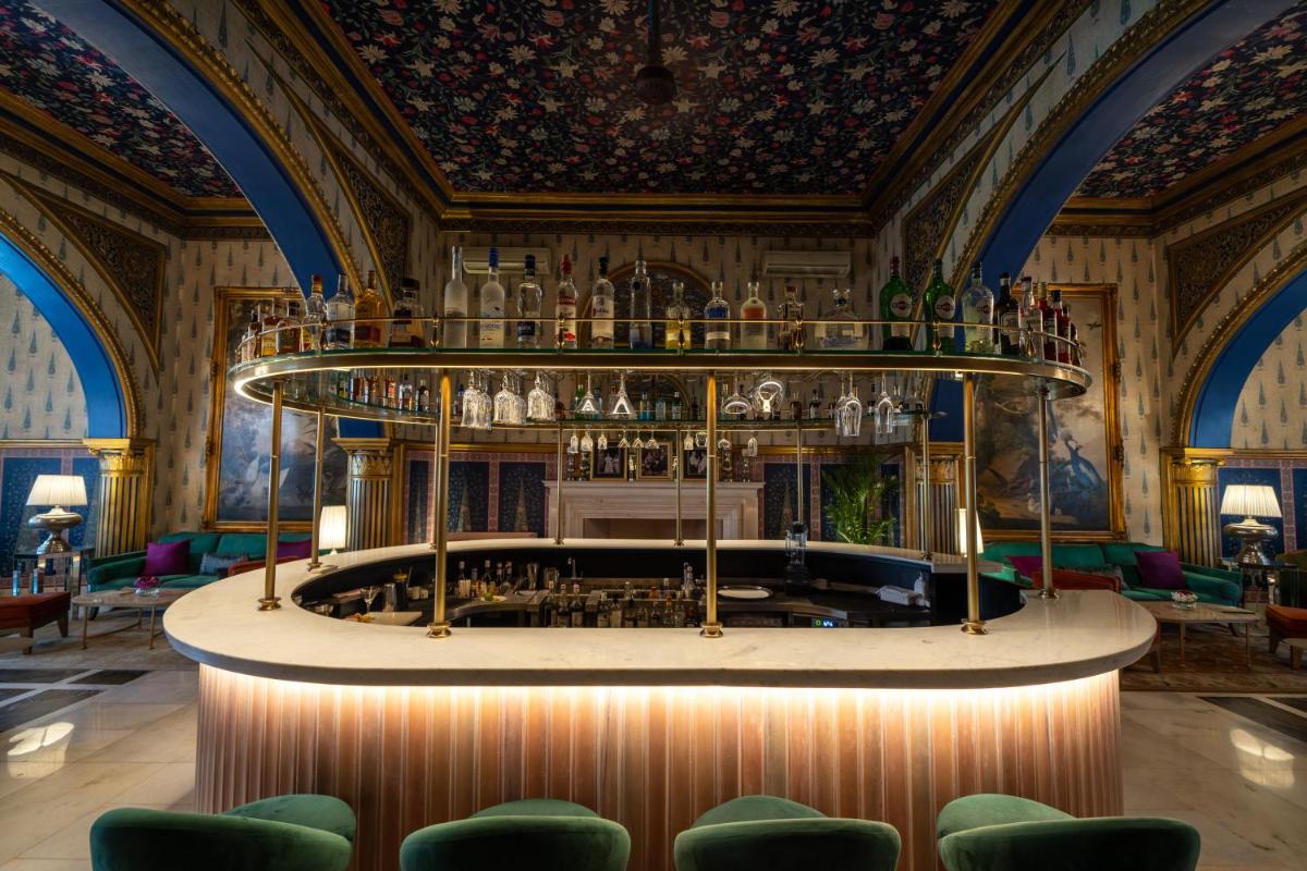 a bar in a room with green chairs at Rajmahal Palace RAAS in Jaipur