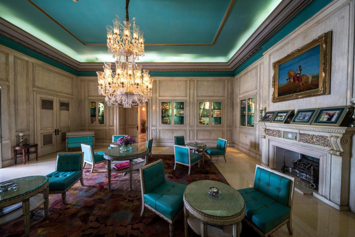 a living room with a chandelier and a fireplace at Rajmahal Palace RAAS in Jaipur