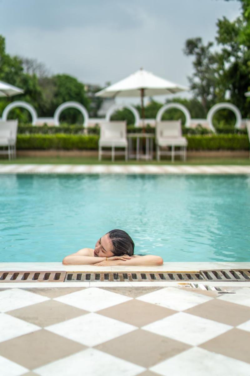 a person laying in the water in a swimming pool at Rajmahal Palace RAAS in Jaipur