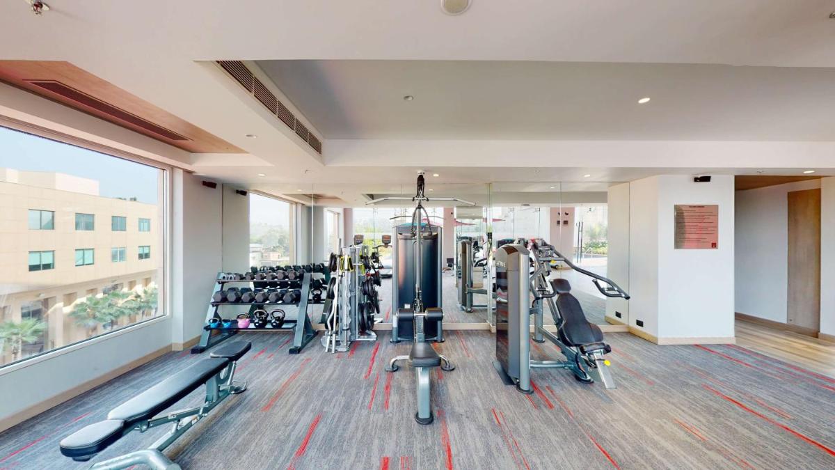 a gym with treadmills and machines in a building at Radisson RED Chandigarh Mohali in Chandīgarh