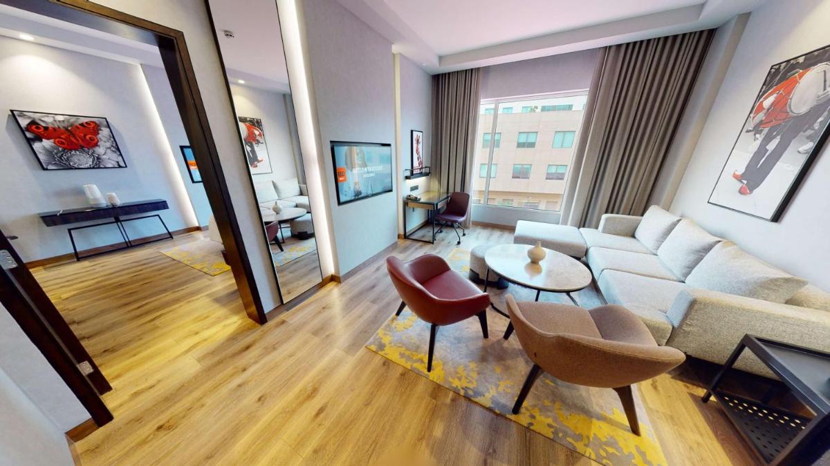 a living room with a couch and a table and chairs at Radisson RED Chandigarh Mohali in Chandīgarh