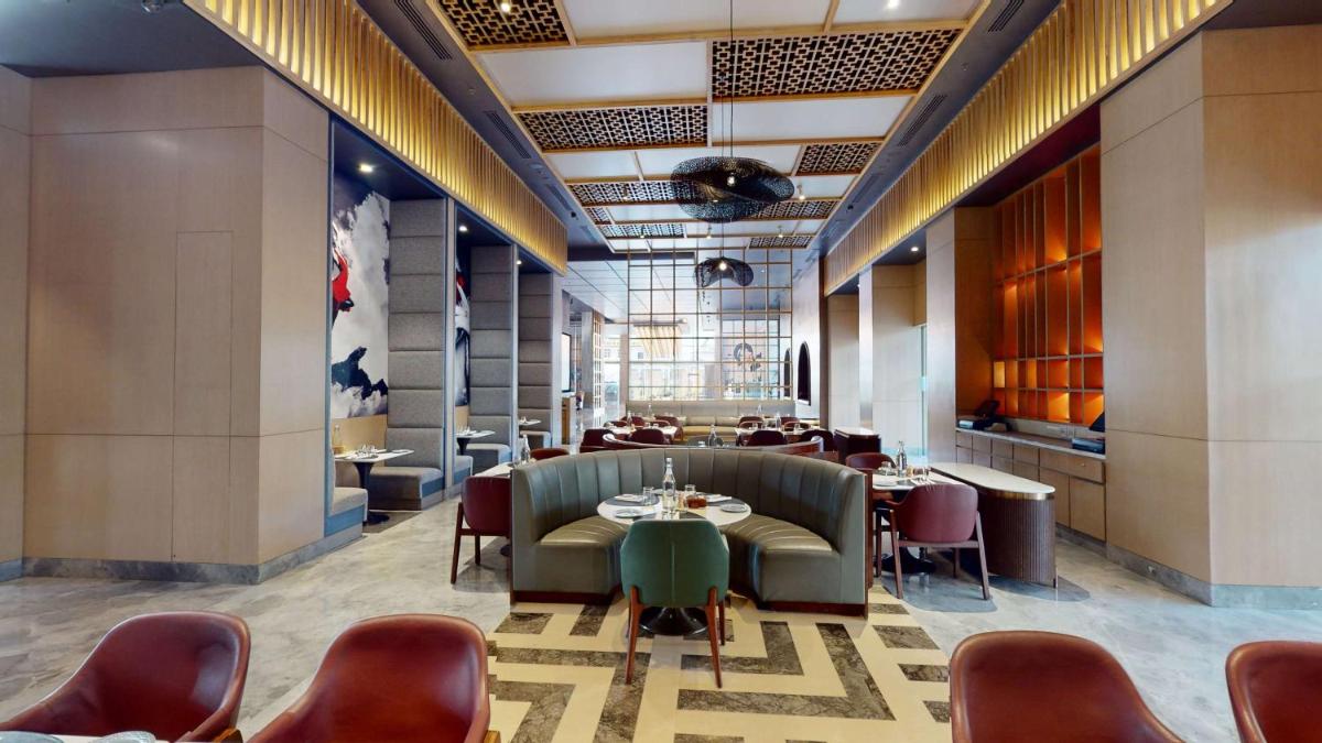 a restaurant with tables and chairs in a room at Radisson RED Chandigarh Mohali in Chandīgarh
