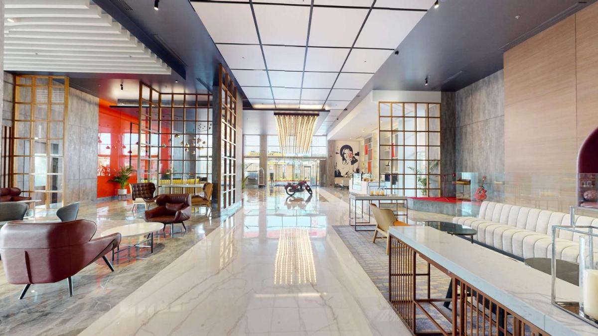 a lobby of a hotel with tables and chairs at Radisson RED Chandigarh Mohali in Chandīgarh