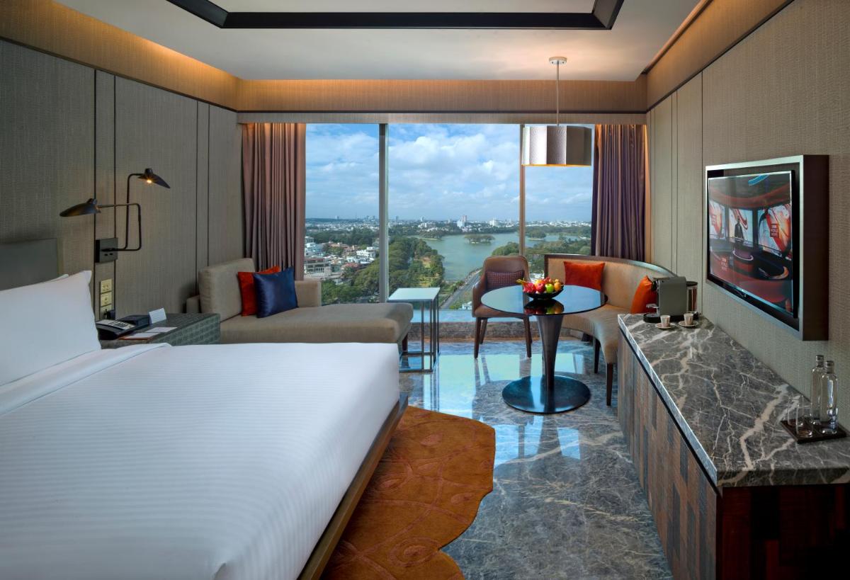 a hotel room with a bed and a living room at Conrad Bengaluru in Bengaluru a hotel room with a bed and a living room at Conrad Bengaluru in Bengaluru