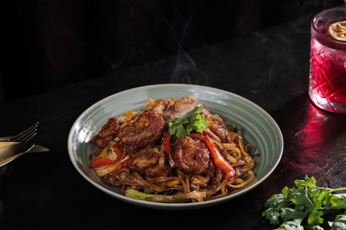 a bowl of noodles with meat and vegetables on a table at Crowne Plaza Kochi by IHG in Cochin