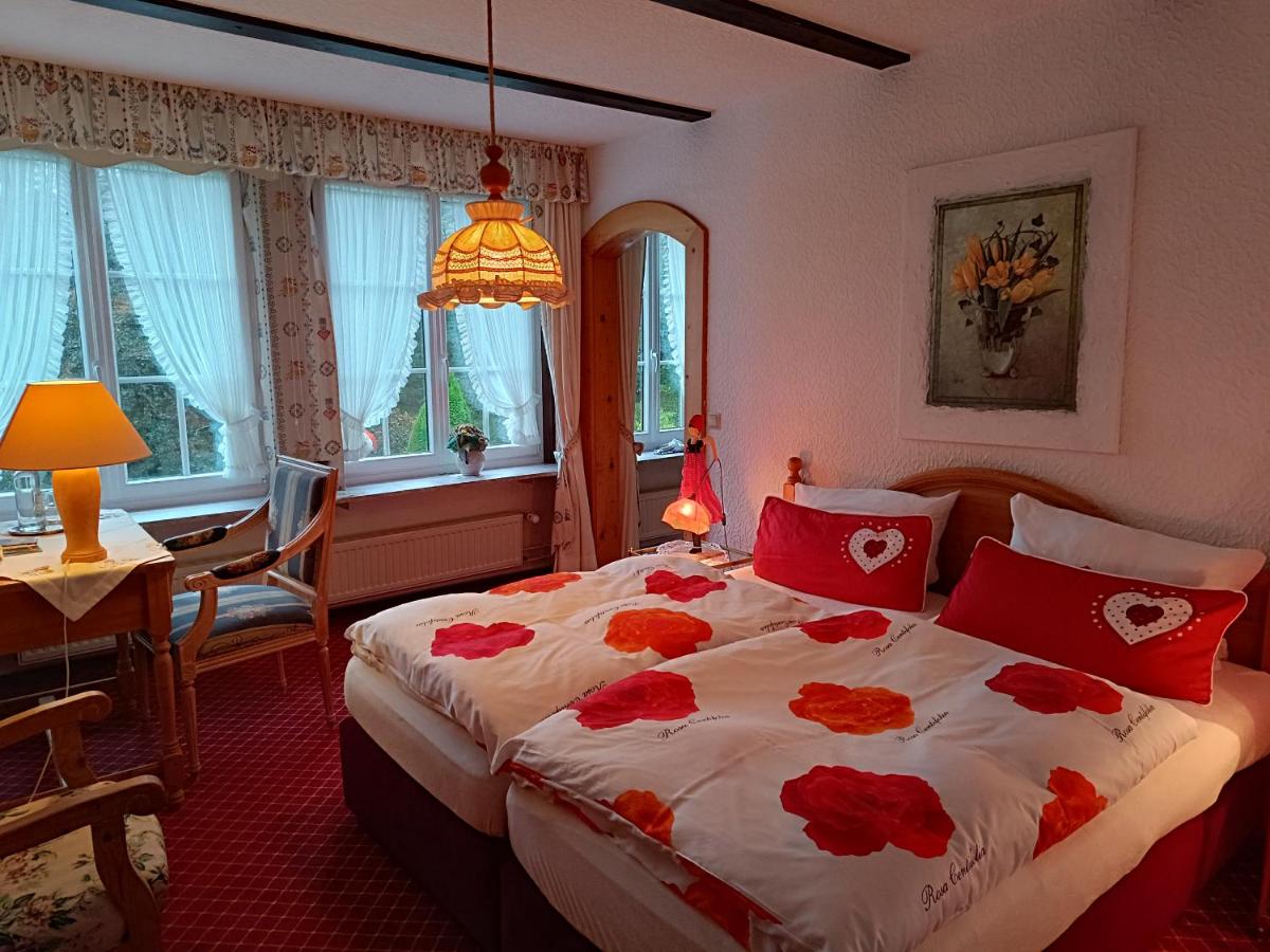 ein Schlafzimmer mit einem großen Bett mit roten Kissen in der Unterkunft Wellness und Romantik Hotel Helmboldt in Bad Sachsa