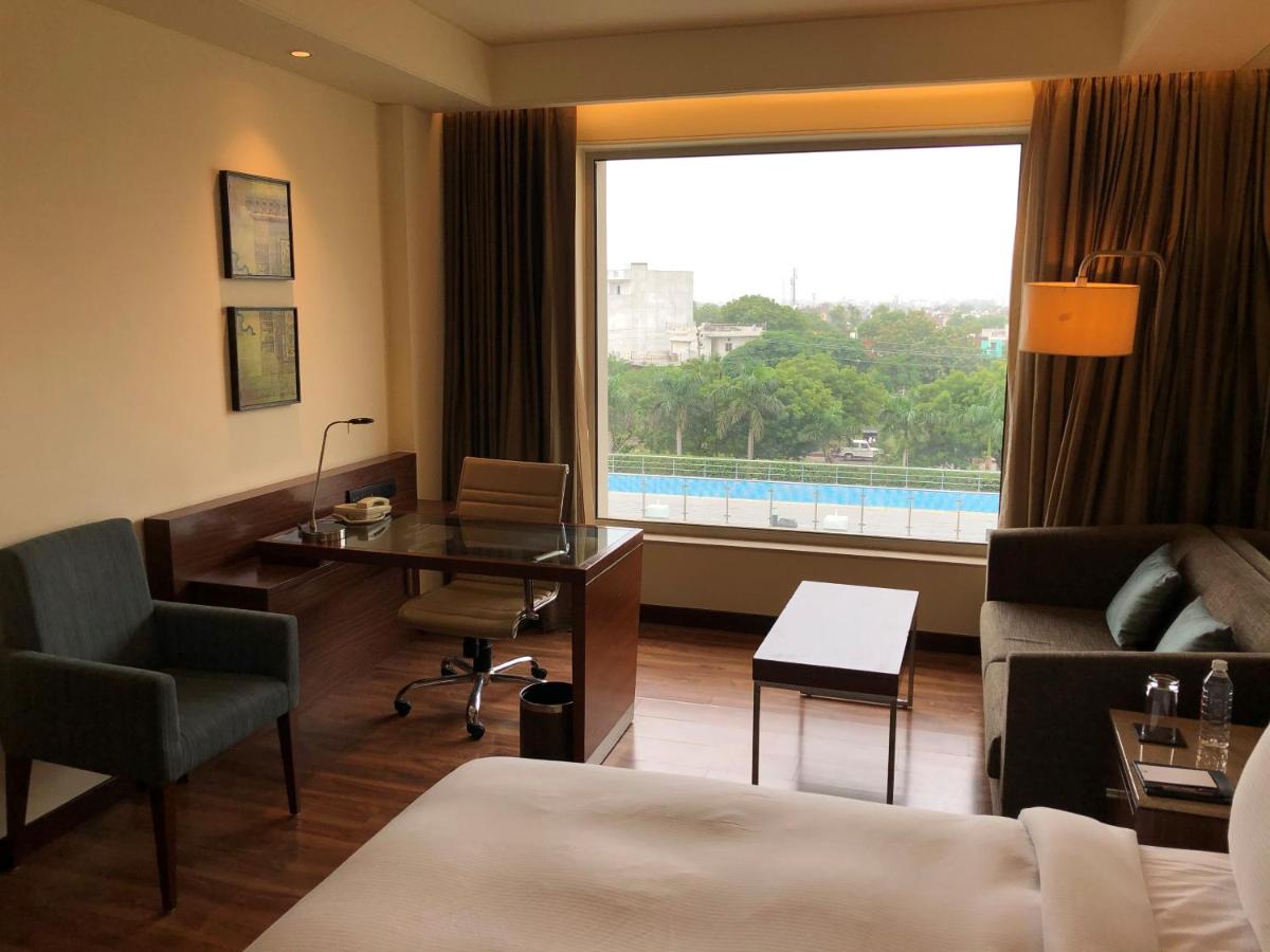 a hotel room with a bed and a desk and a window at DoubleTree by Hilton Agra in Agra