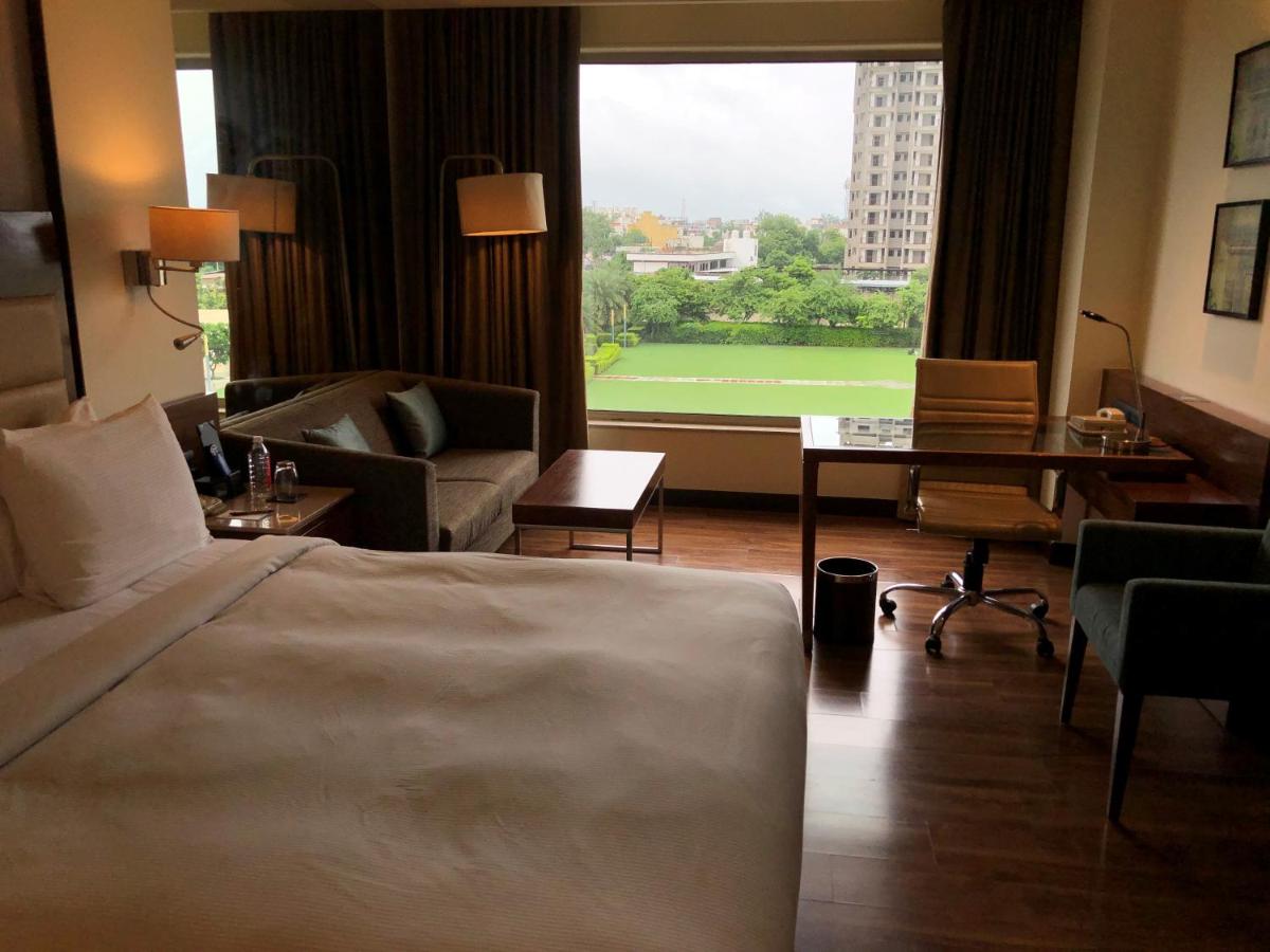 a hotel room with a bed and a large window at DoubleTree by Hilton Agra in Agra