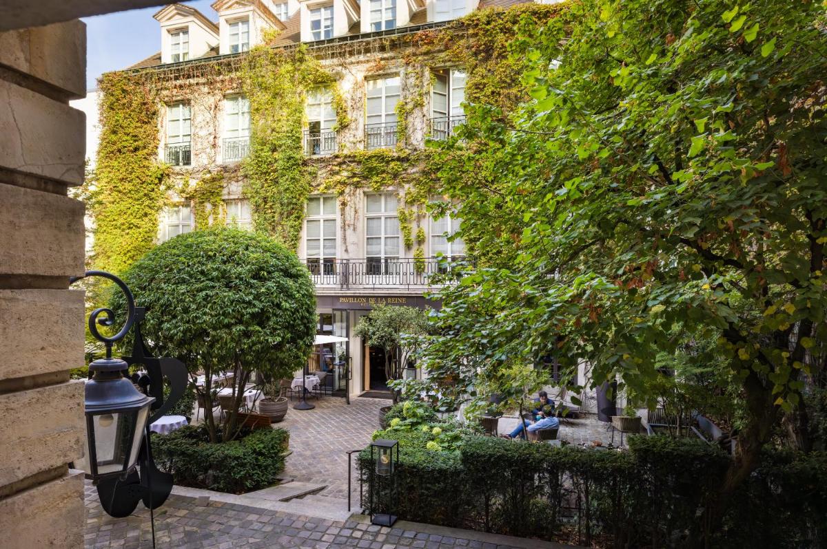 un bâtiment avec du lierre sur son côté dans l'établissement Le Pavillon de la Reine & Spa, Place des Vosges, à Paris