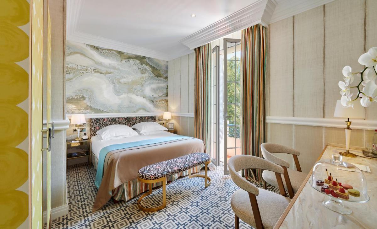 une chambre d'hôtel avec un lit et un tableau au mur dans l'établissement Hôtel Belles Rives, à Juan-les-Pins
