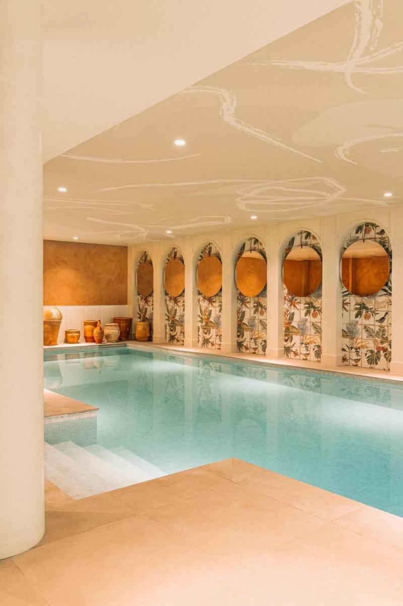 une piscine dans un bâtiment avec un plafond dans l'établissement Bloom House Hôtel & SPA, à Paris