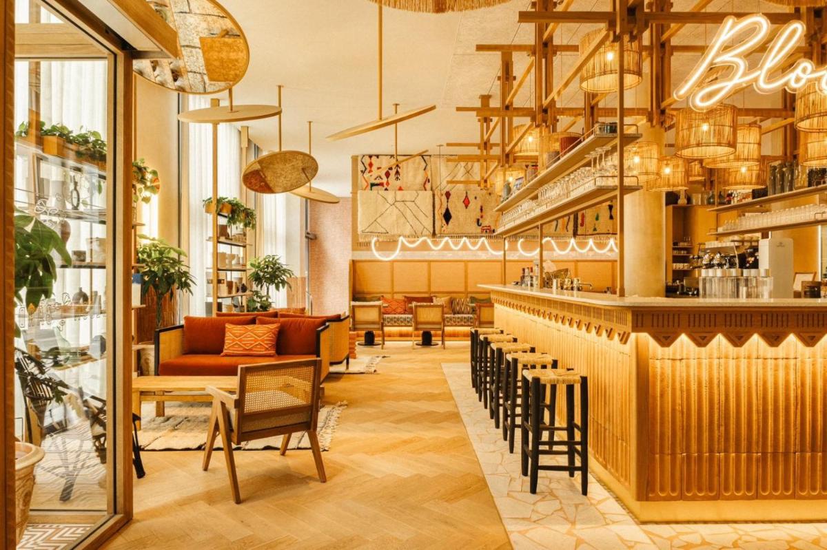 un restaurant avec un bar avec des chaises et des tables dans l'établissement Bloom House Hôtel & SPA, à Paris