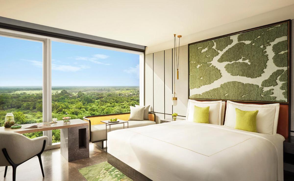 a bedroom with a white bed and a large window at Taj The Trees, Mumbai in Mumbai