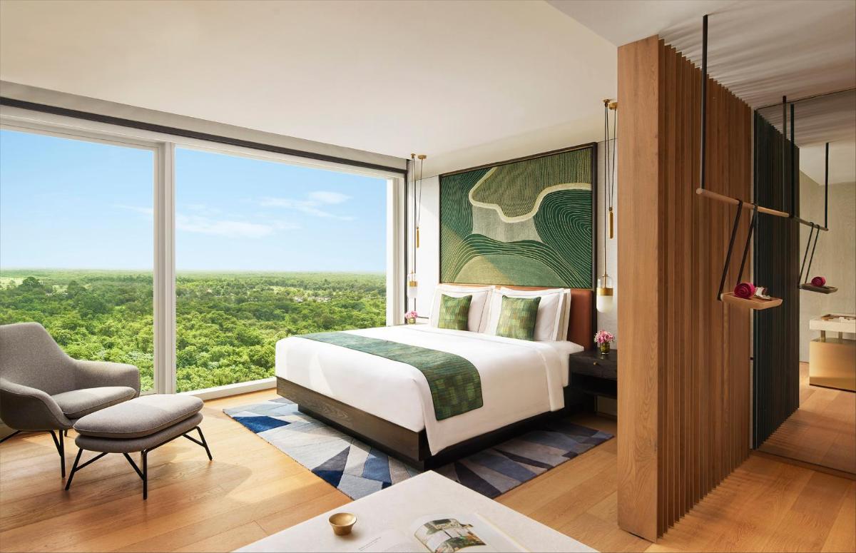 a bedroom with a bed and a large window at Taj The Trees, Mumbai in Mumbai