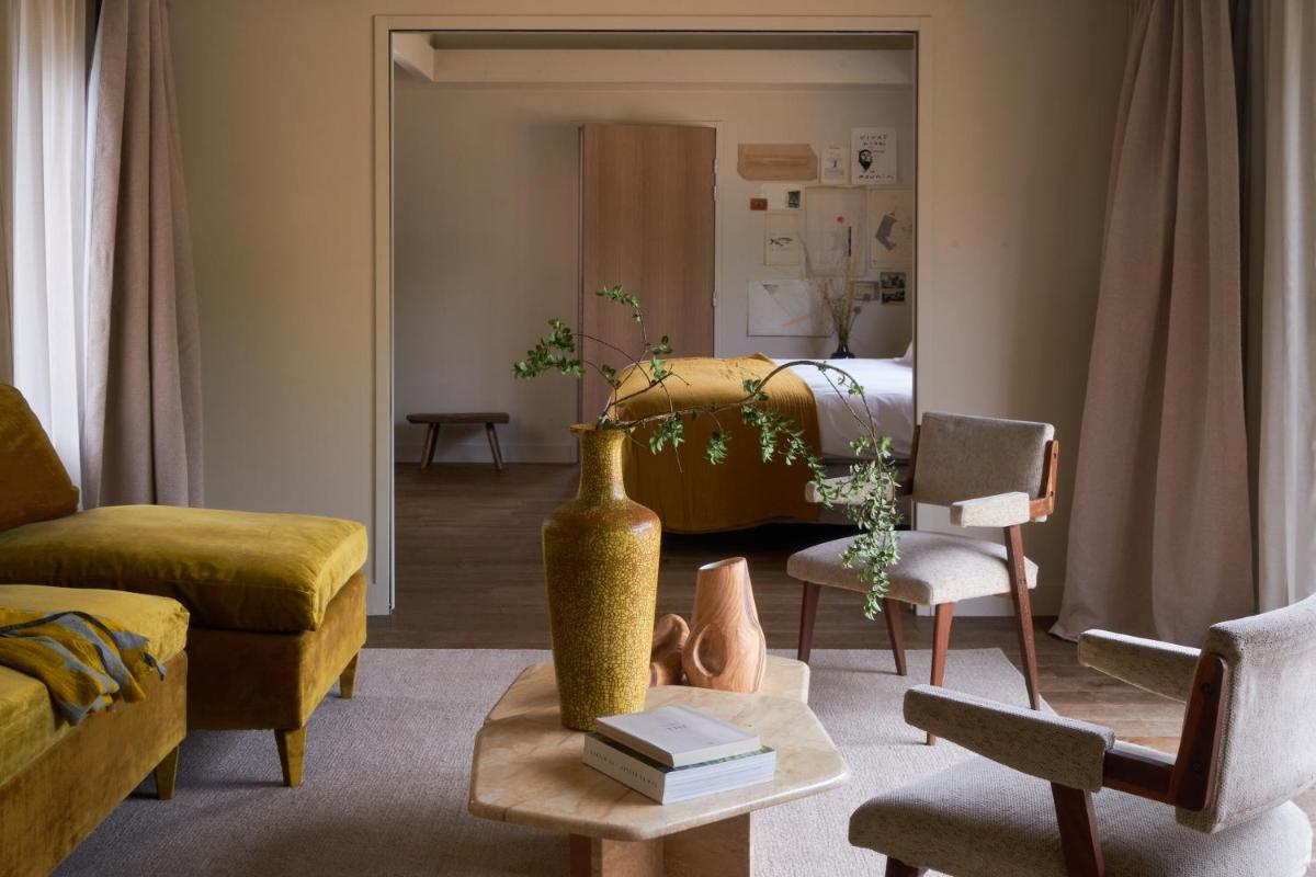 un salon avec un vase en or sur une table dans l'établissement Les Sources de Cheverny, à Cheverny 37 autres photos