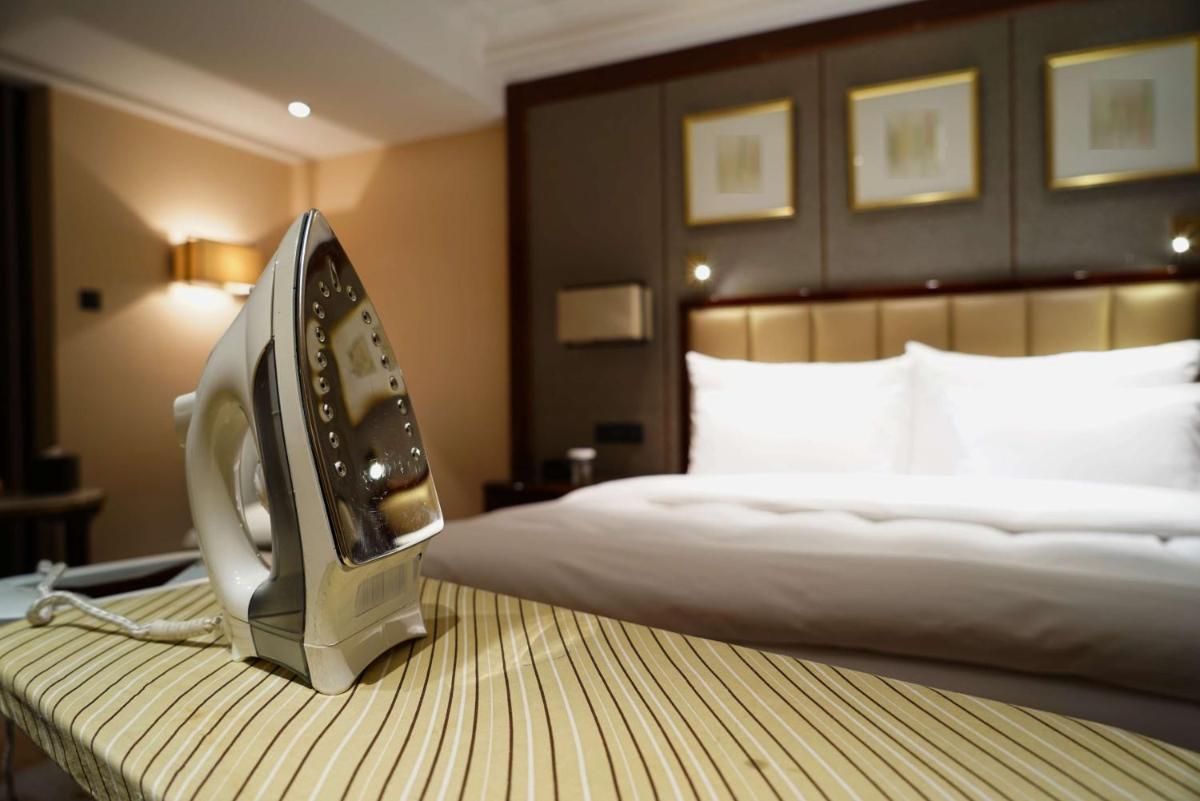 a hotel room with a bed and an iron on a table at Radisson Blu Jaipur in Jaipur
