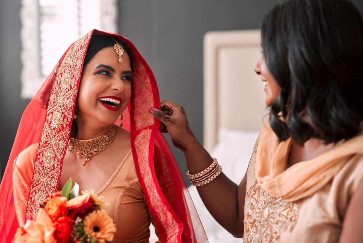 a bride getting her makeup done by a woman at Radisson Hyderabad Hitec City in Hyderabad