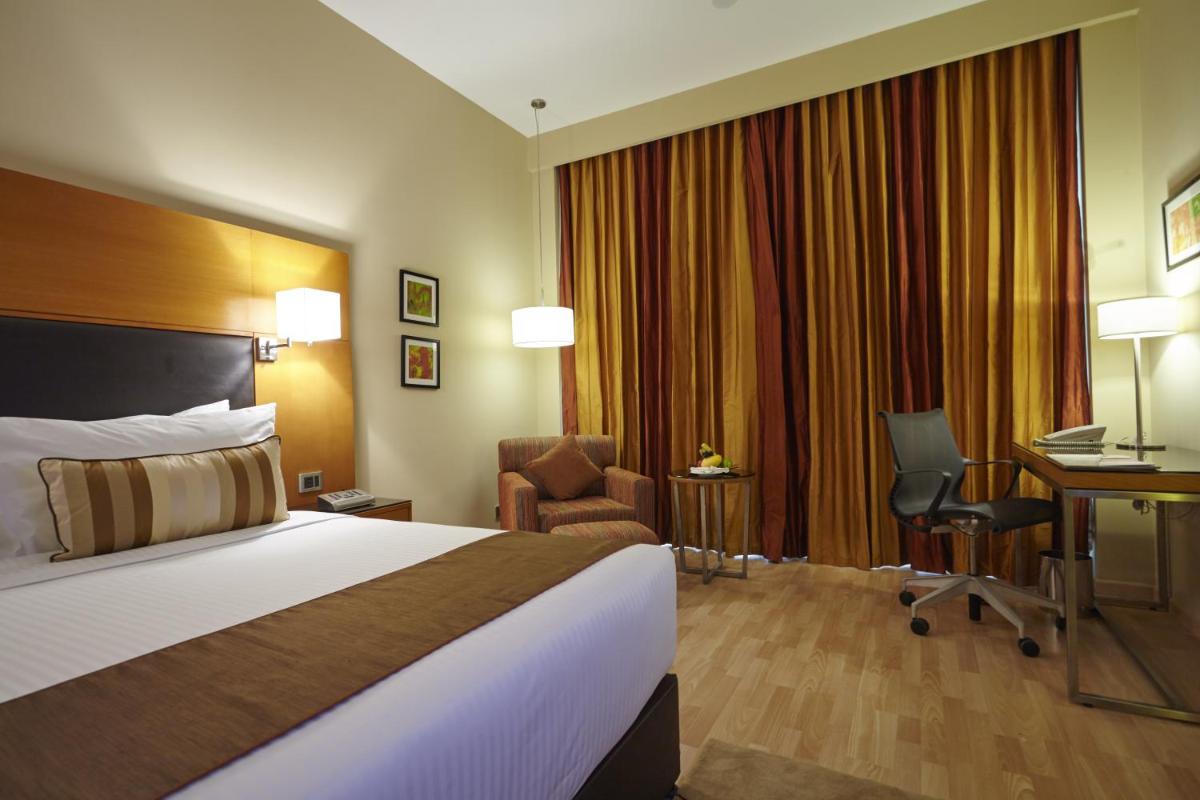 a hotel room with a bed and a desk at Turyaa Chennai - OMR IT Expressway in Chennai