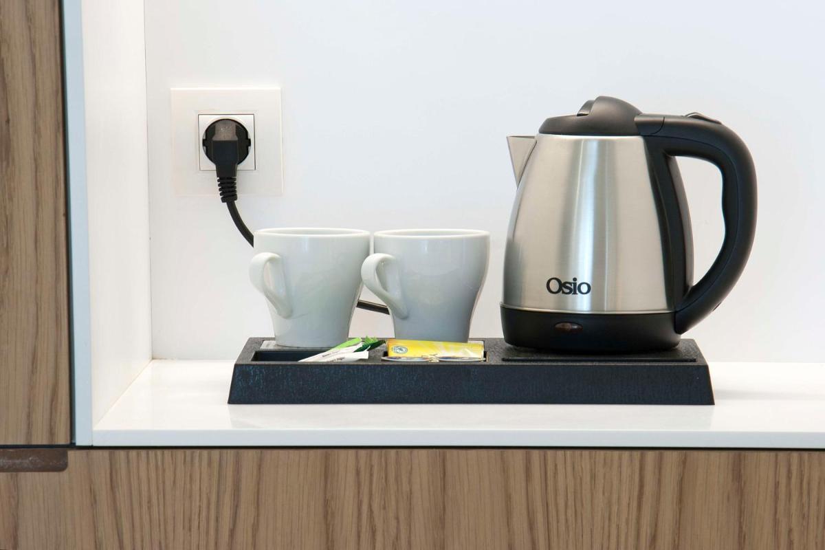 a coffee pot and two cups on a shelf at Radisson Blu Kochi in Cochin