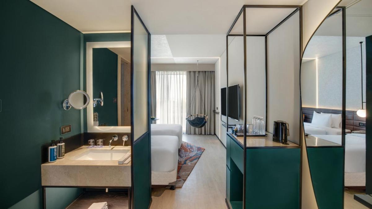 a bathroom with a sink and a large mirror at Novotel Pune Viman Nagar Road in Pune