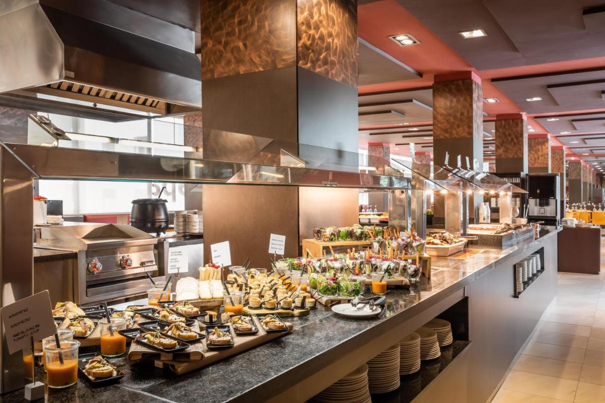una línea de buffet de comida en un restaurante en ALEGRIA Plaza Paris 4*Sup, en Lloret de Mar