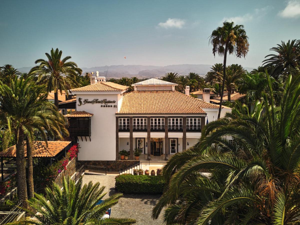 Una gran casa blanca con palmeras delante. en Seaside Grand Hotel Residencia - Gran Lujo, en Maspalomas