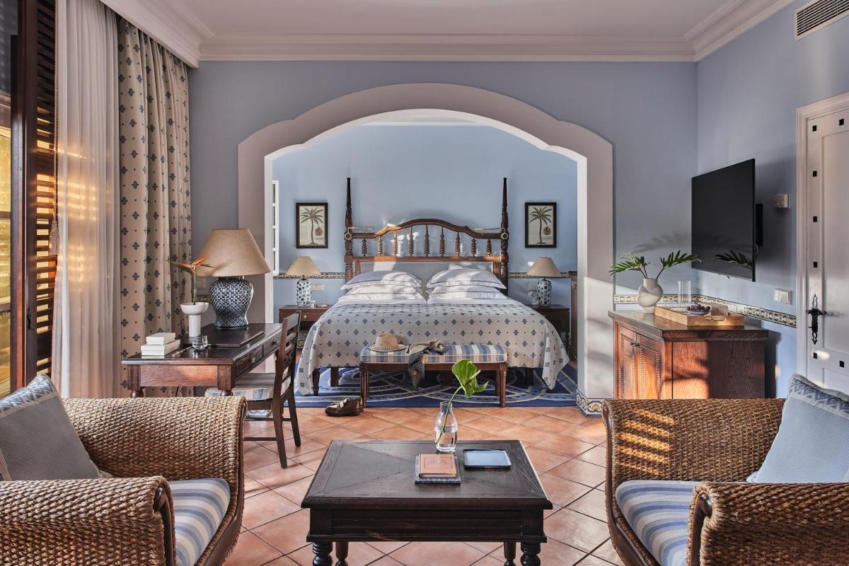 Un dormitorio con una cama y una sala de estar. en Seaside Grand Hotel Residencia - Gran Lujo, en Maspalomas