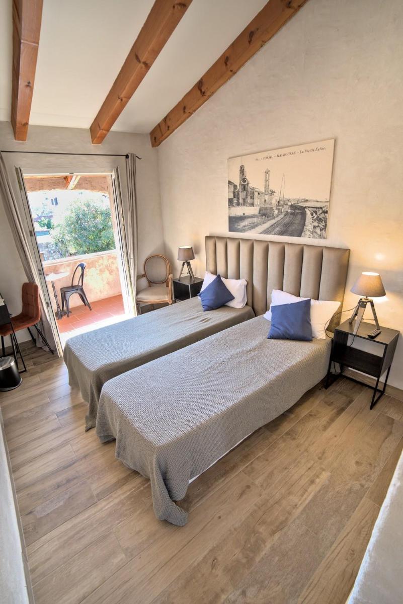 une chambre avec deux lits aux oreillers bleus dans l'établissement Hôtel Casa Rossa & Spa, à LʼÎle-Rousse 137 autres photos