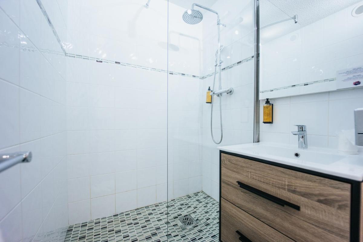 une salle de bain blanche avec douche et lavabo dans l'établissement Le Drip's, à Marseille