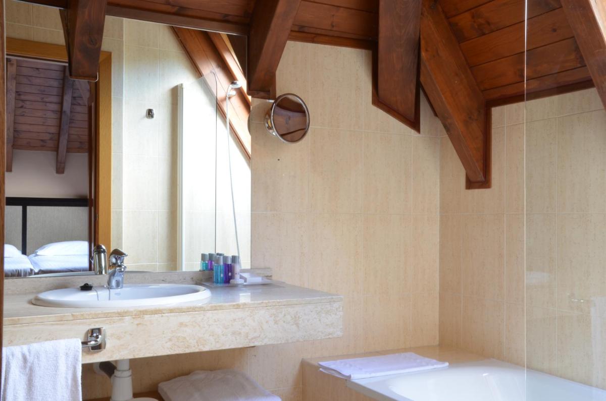 un baño con lavabo y espejo en Hotel Spa Acevi Val d’Aran, en Vielha