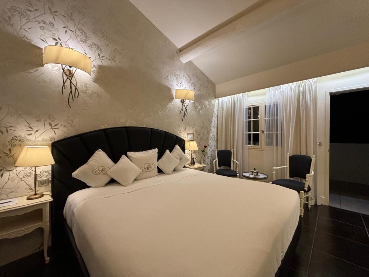 une chambre avec un grand lit aux draps et oreillers blancs dans l'établissement Auberge de Cassagne & Spa, au Pontet 63 autres photos