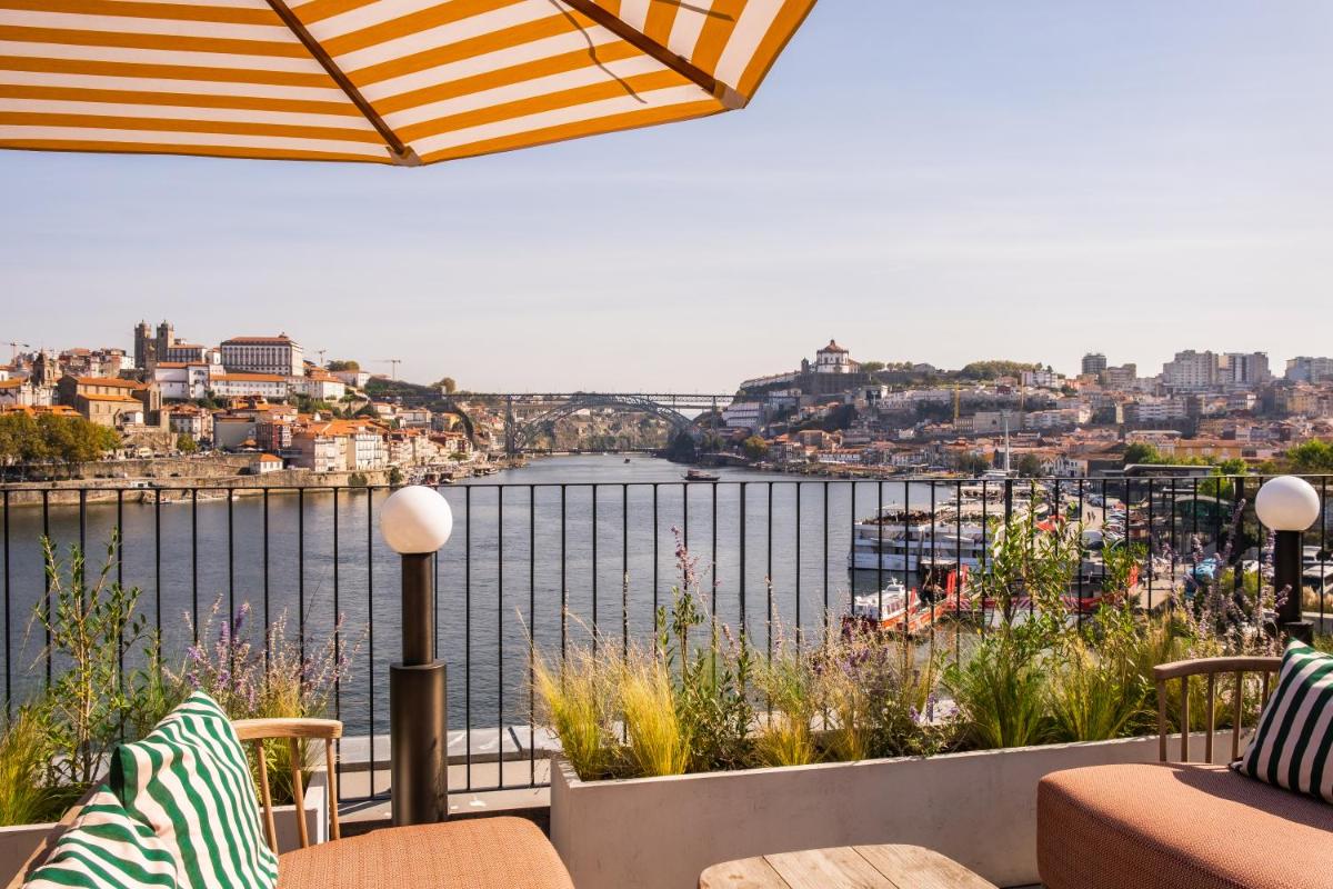 uma varanda com vista para a água em The Rebello Hotel & Spa - Small Luxury Hotels Of The World em Vila Nova de Gaia uma varanda com vista para a água em The Rebello Hotel & Spa - Small Luxury Hotels Of The World em Vila Nova de Gaia