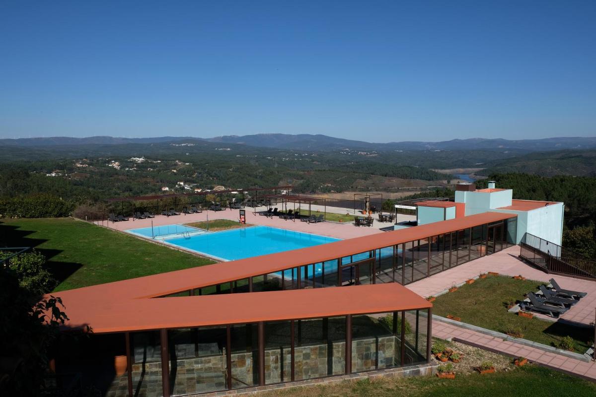 uma vista externa de um edifício com piscina em Hotel Da Montanha em Pedrógão Pequeno uma vista externa de um edifício com piscina em Hotel Da Montanha em Pedrógão Pequeno