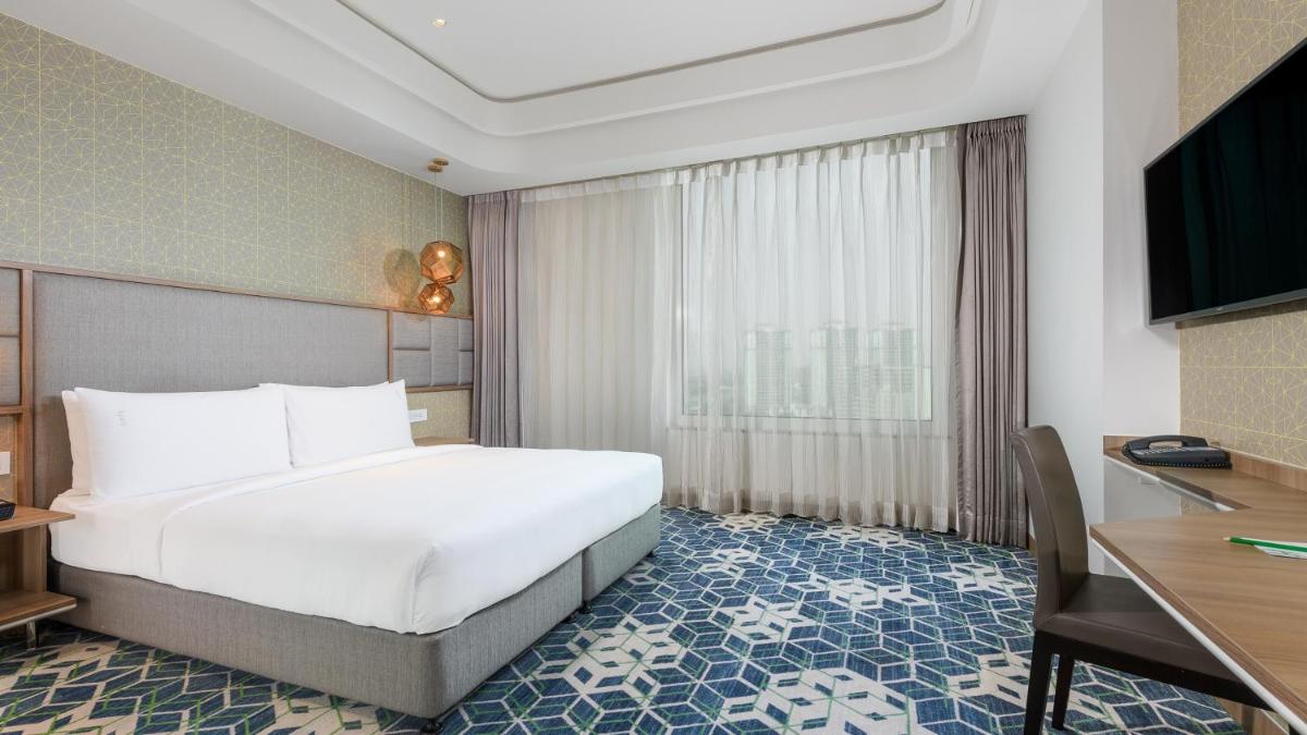 a hotel room with a large bed and a desk at Holiday Inn Gurugram Sector 90 by IHG in Gurgaon