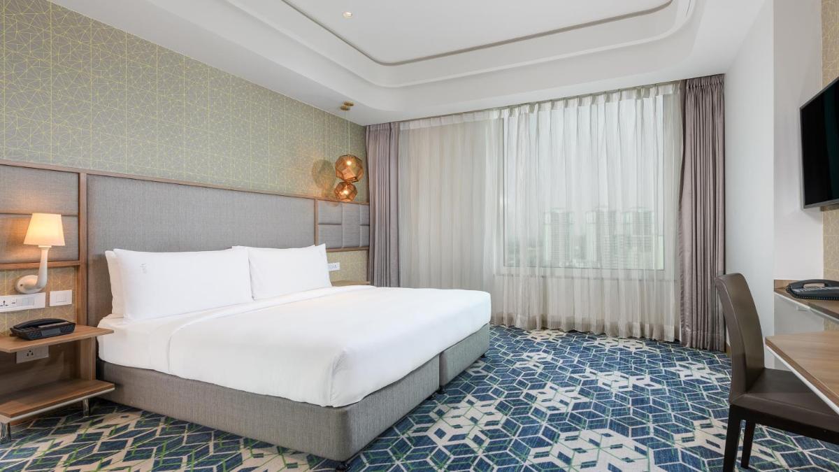 a hotel room with a large bed and a desk at Holiday Inn Gurugram Sector 90 by IHG in Gurgaon
