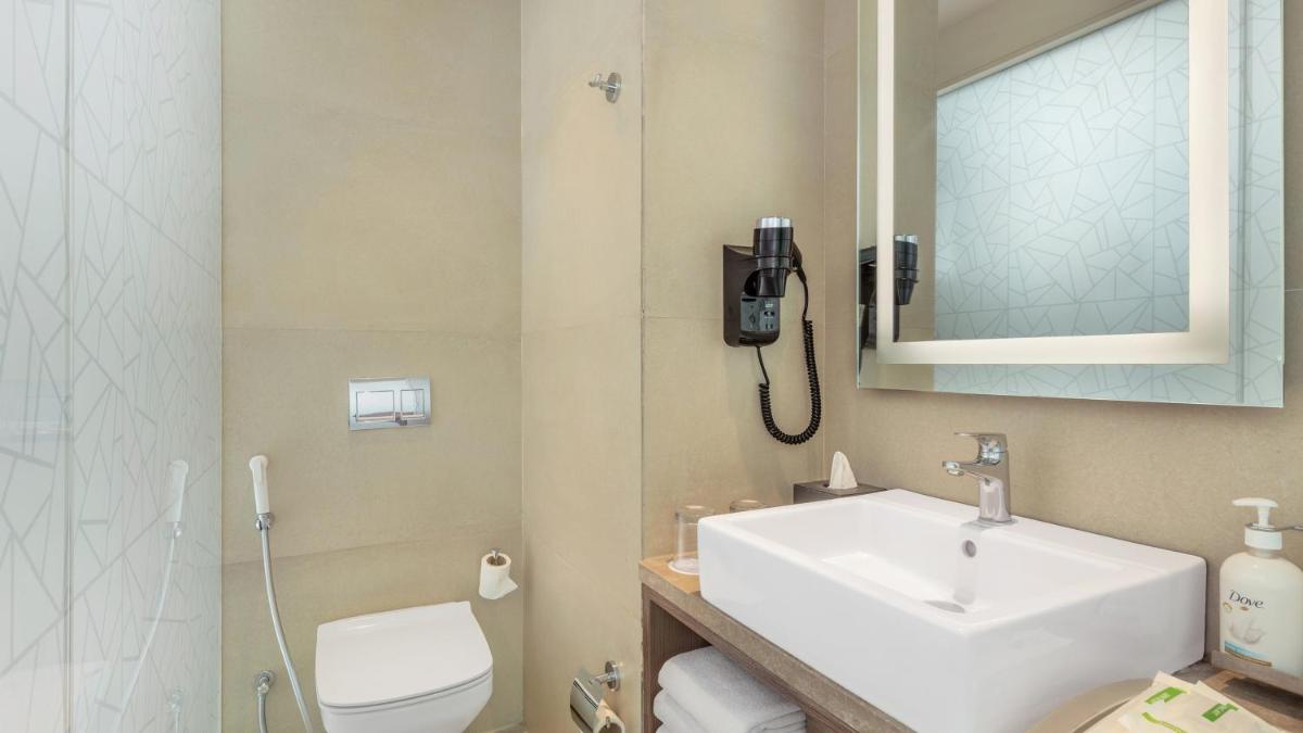 a bathroom with a sink and a toilet and a phone at Holiday Inn Gurugram Sector 90 by IHG in Gurgaon
