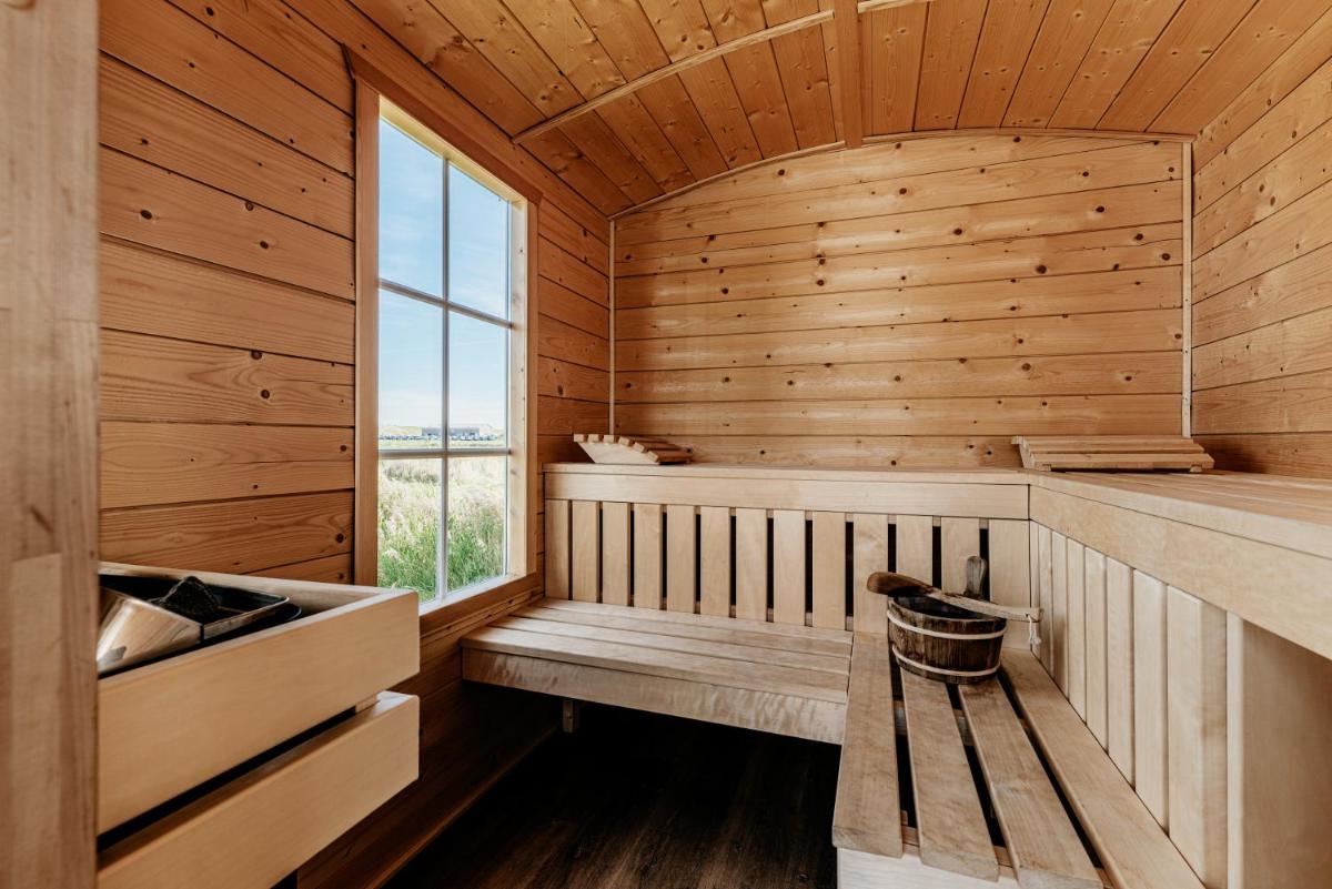 eine Sauna mit einer Bank und einem Fenster in der Unterkunft Seaside 43 in Sankt Peter-Ording