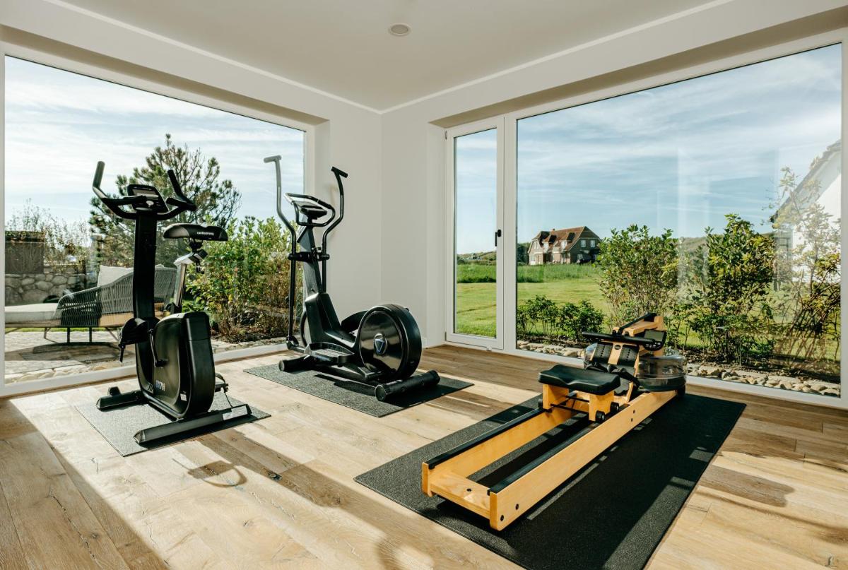 einen Fitnessraum mit zwei Laufbändern und zwei Trainingsgeräten in der Unterkunft Seaside 43 in Sankt Peter-Ording
