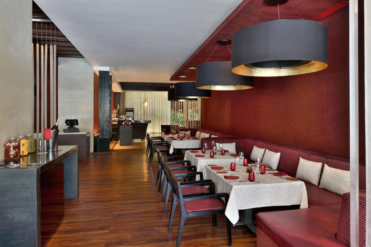 a restaurant with tables and chairs in a room at The Westin Hyderabad Mindspace in Hyderabad