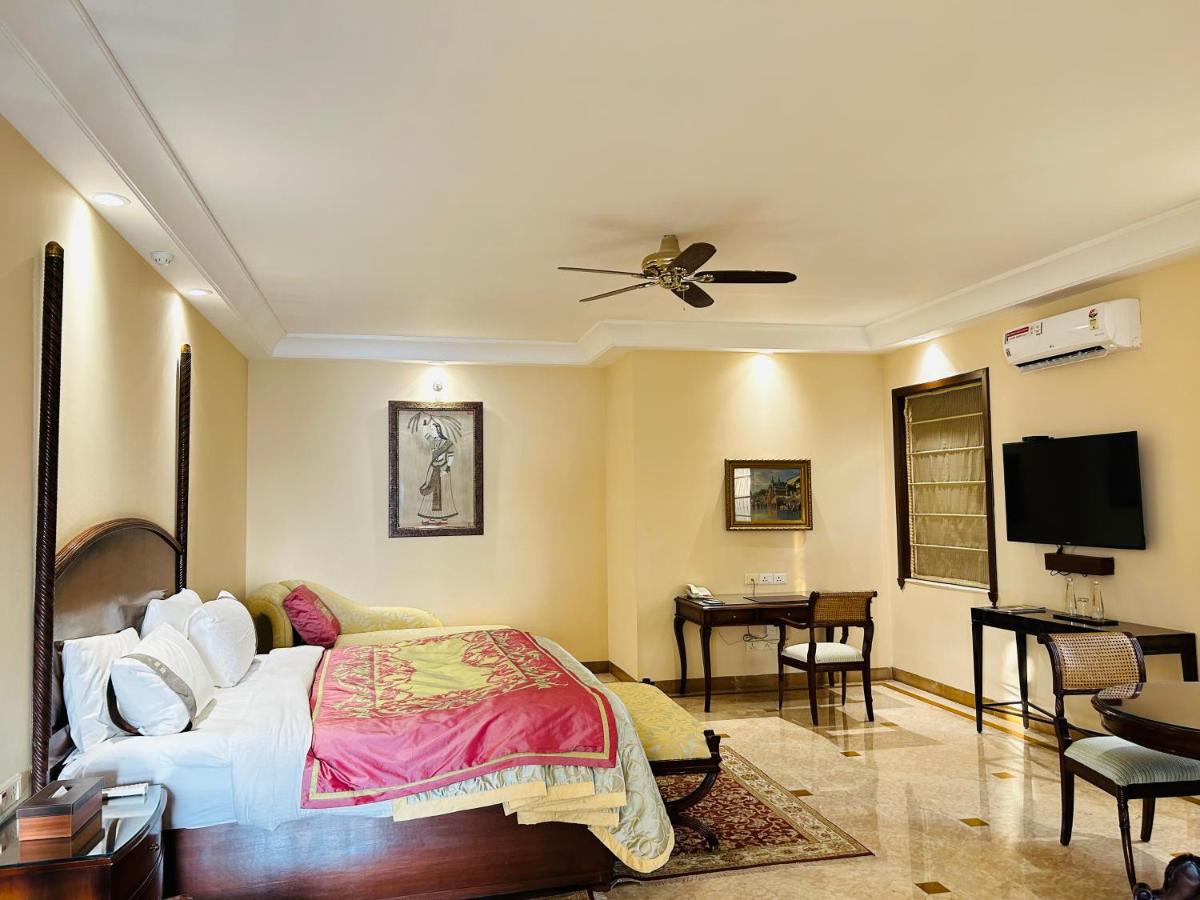 a bedroom with a bed and a flat screen tv at The Lalit Laxmi Vilas Palace in Udaipur